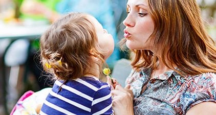 Partnersuche mit Kind: Mutter küsst Kind